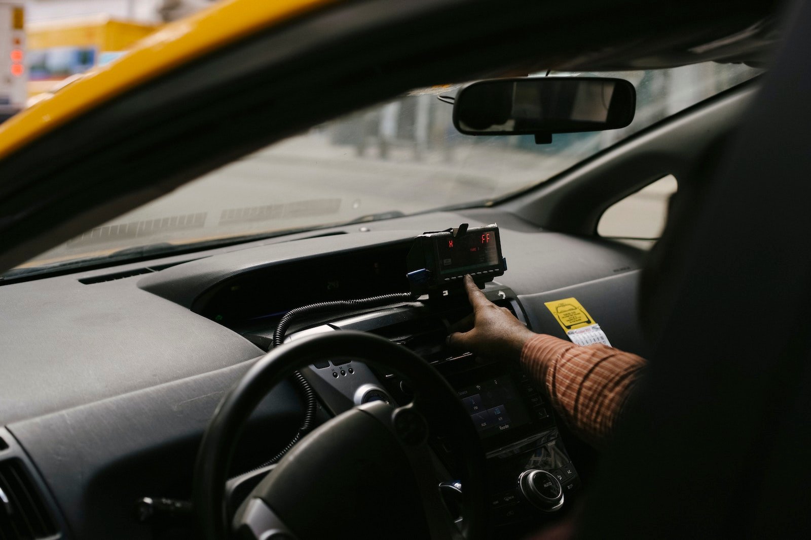 Crop ethnic man with navigator in taxi